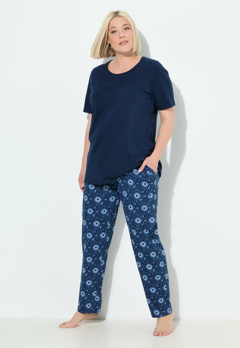 Donkerblauw katoenen t-shirt met korte mouwen en een ontspannen pasvorm, gecombineerd met gestreepte pyjamabroek met donkere en lichte blauwe cirkelvormige ontwerpen.