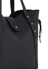 Zwarte leren tote bag met een gestructureerd oppervlak, voorzien van een klep-sluiting, gouden studs en lange handvaten.