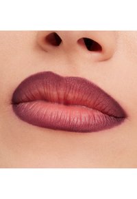 Matte huulilla on syvän luumun sävystä pehmeään mauveen ulottuva värigradientti, jossa on tarkasti määritellyt muodot ja hienovaraiset tekstuurivaihtelut.