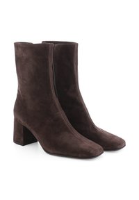 Braune Wildleder-Stiefeletten mit Blockabsatz, die eine glatte Textur, eine schlanke Passform und eine spitze Zehenpartie aufweisen. Seitlicher Reißverschluss für einfaches An- und Ausziehen.