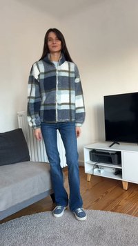 Fleecepaita sinisen, valkoisen ja harmaan ruutukuviolla; pehmeä tekstuuri; yhdistetty vaaleansinisiin farkkuihin ja sinisiin lenkkareihin.