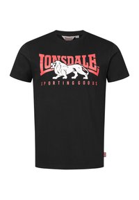 Juodas medvilnės marškinėliai su baltu liūto grafinu ir raudonais užrašais "Lonsdale Sporting Goods". Klasikinis apvalus kaklas ir trumpomis rankovėmis.