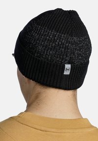 Knitted black beanie with a textured design and cuffed hem. Features a small gray logo tag on the back, fitted to the head.