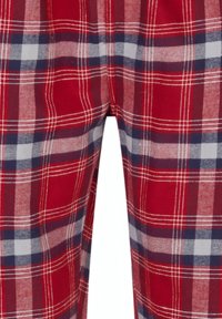 Close-up van een rode, marineblauwe, witte en beige geruite stof, met elkaar kruisende verticale en horizontale lijnen die een tartanpatroon vormen op zacht materiaal.