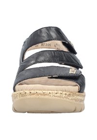 Sandale en cuir noir avec trois largeurs de brides, une semelle intérieure rembourrée beige et une semelle texturée de couleur claire. Agrémentée d'un petit détail métallique.