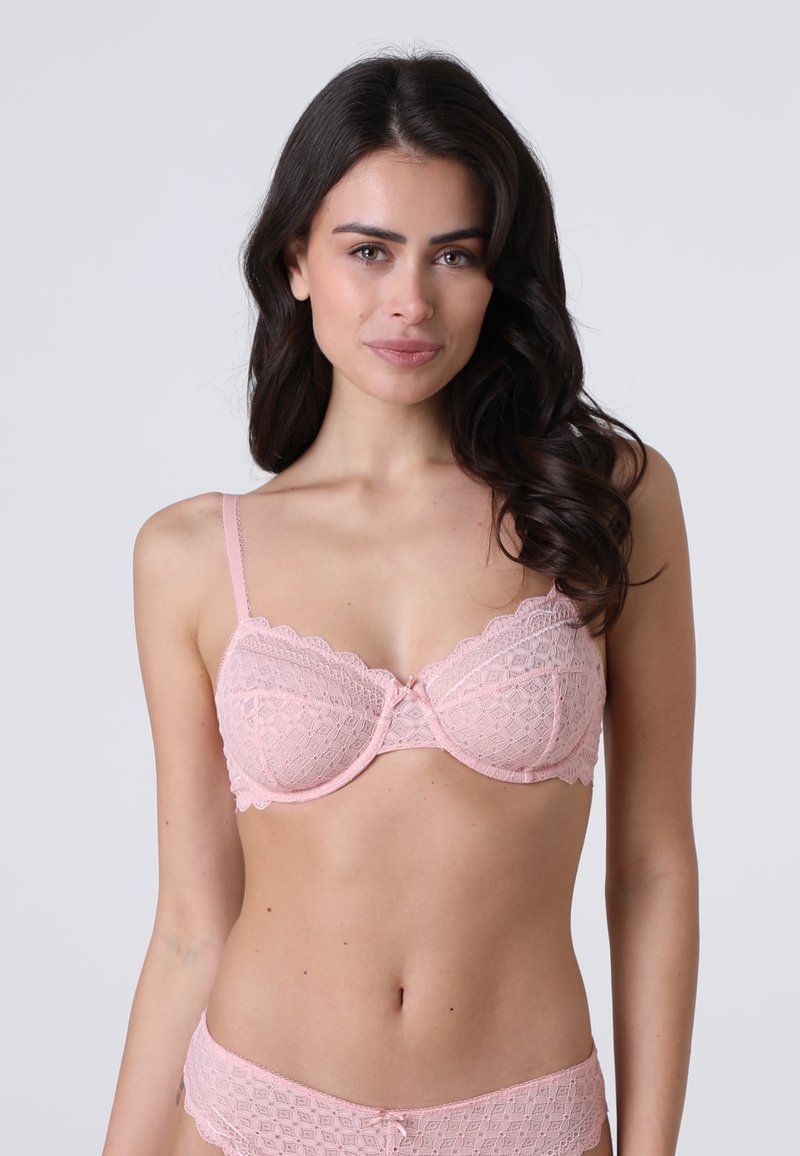 Reggiseno in pizzo di un delicato rosa con bordi scallop, supporto con ferretto e un piccolo fiocco al centro, abbinato a slip in pizzo coordinati.