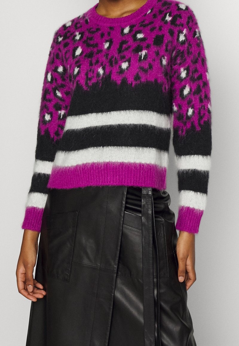 Fuzzy pink and black sweater featuring a leopard print design, black stripes, and white accents. The sweater has long sleeves and a crew neckline.
