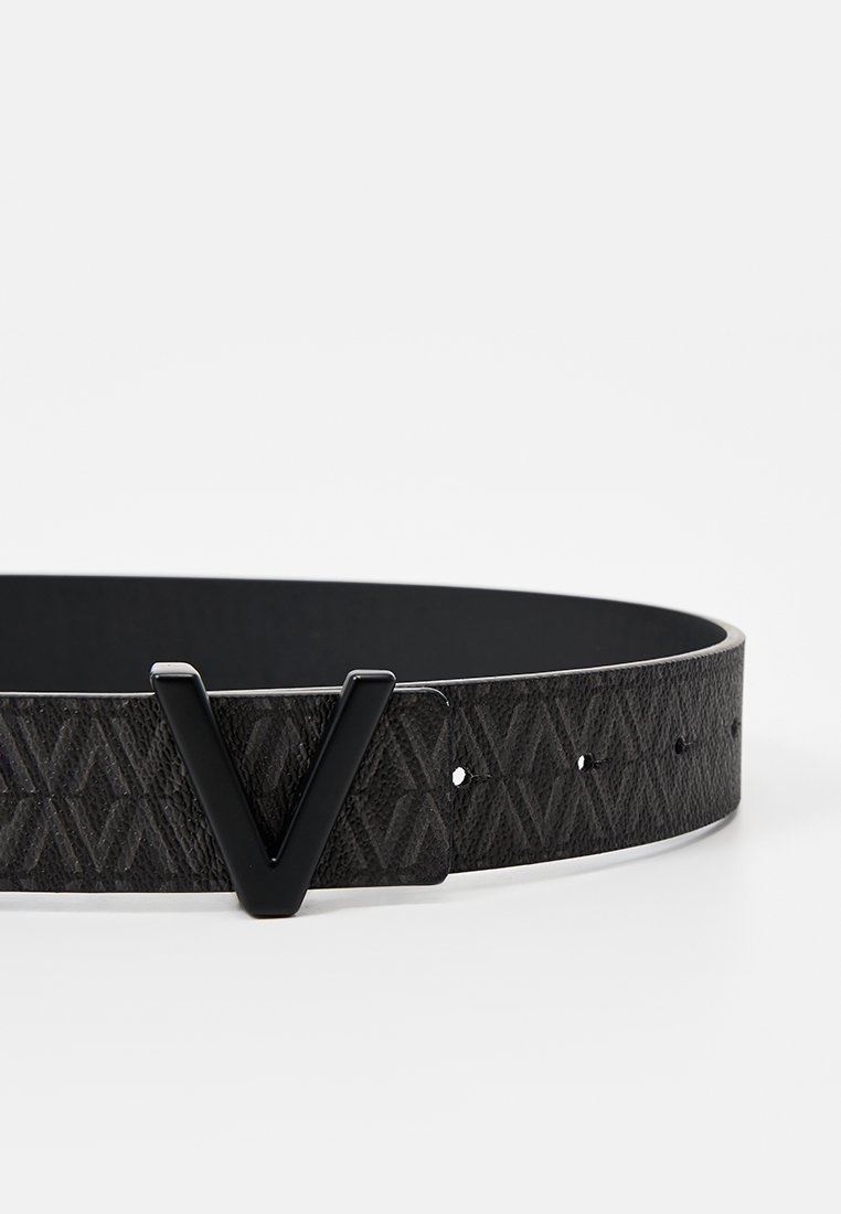 Ceinture en cuir noir avec un motif en losanges gaufré, présentant une boucle en métal noire en forme de V et des trous réglables le long de la sangle.