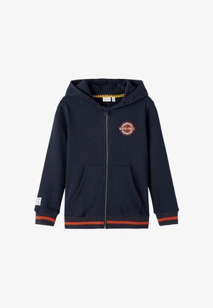 Sweat à capuche zippé bleu marine en tissu doux. Présente un logo à l'avant, deux poches et des bandes orange contrastantes sur les poignets et le bas. Design à capuche.