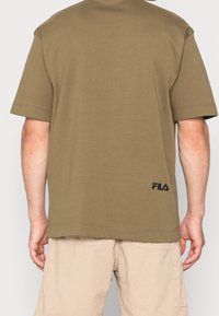 T-shirt en coton vert olive à manches courtes, avec un logo 'FILA' brodé en noir dans le dos et une coupe décontractée.