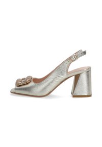 Metallisch silberner Slingback-High Heel mit offenem Zehenbereich, dekorativer Schnalle und strukturiertem Oberflächenmaterial. Chunky, geometrischer Blockabsatz.