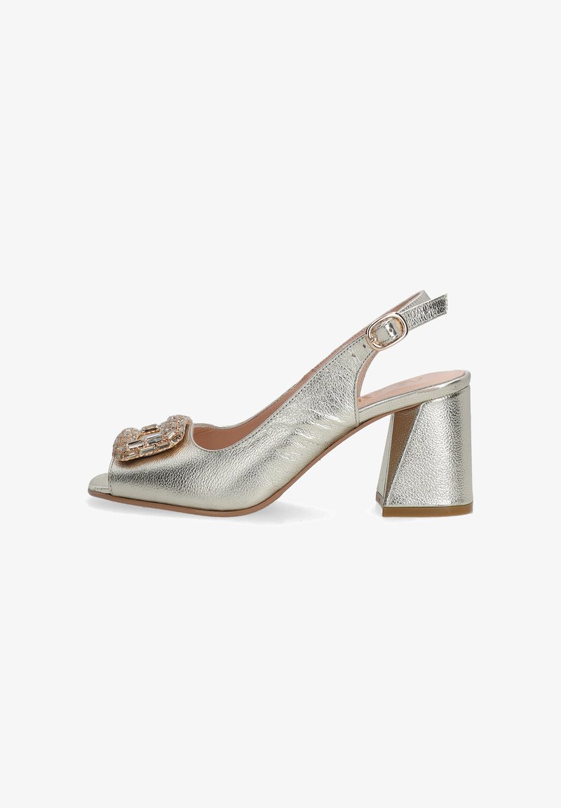 Metallisch silberner Slingback-High Heel mit offenem Zehenbereich, dekorativer Schnalle und strukturiertem Oberflächenmaterial. Chunky, geometrischer Blockabsatz.