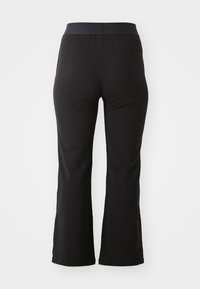 Black flared pants made of soft fabric, featuring a wide elastic waistband and a smooth, unembellished surface with no visible pockets.