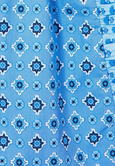 Tela azul con un intrincado patrón de formas de diamante, alternando entre azul claro y oscuro, con acentos florales en negro y blanco.