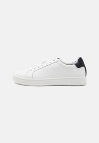 Sneaker bianca in pelle con finitura liscia, punta tonda, tallone in tessuto blu navy a contrasto e suola in gomma bianca. Presenta una chiusura con lacci piatti.