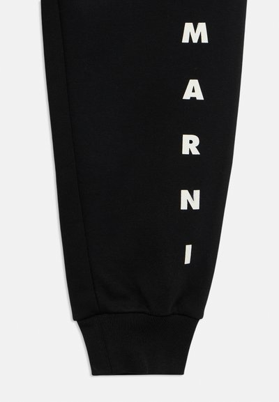 Calças de treino pretas com o texto branco "MARNI" impresso verticalmente ao longo da perna esquerda; punhos canelados e textura suave de algodão.