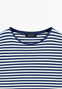 Navy blue and white horizontal striped crewneck shirt with a fabric label reading "Massimo Dutti Made in Morocco" at the neckline.
