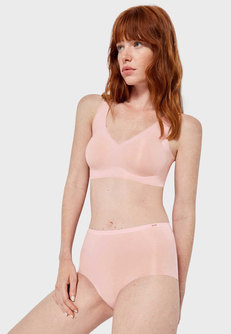Lichtroze naadloze bralette en hooggesneden broekje set in een zachte stof. De bralette heeft een V-hals en brede bandjes; het broekje heeft een gladde tailleband.