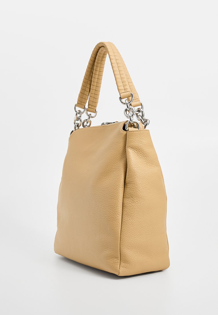 Brūns ādas rokassomu ar teksturētu, austu rokturi. Iezīmējas ar sudraba metāla detaļām un gludu, nedaudz strukturētu korpusu.