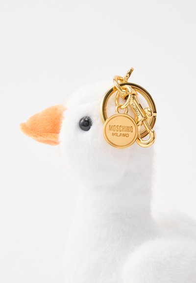 Λευκό μαλακό μπρελόκ χήνας με πορτοκαλί ράμφος, μαύρο μάτι και χρυσούς κρίκους και ταμπελάκι χαραγμένο με "Moschino Milano".
