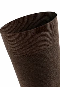 Brązowa dziana skarpetka o ribbowanej teksturze, z szerokim mankietem u góry i gładkim fasonem, idealna dla komfortu i dopasowania.