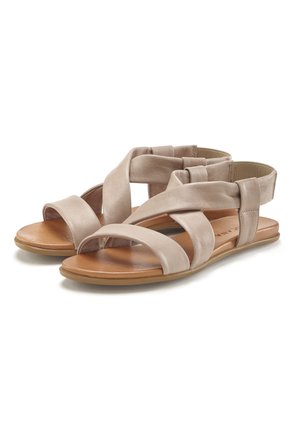 Beige leather sandals with cross strap design, flat sole, and elastic back. Smooth texture with a light sheen and brown insole.