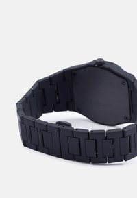 Relógio de pulso preto em metal com caixa retangular e bracelete de elos. Apresenta um acabamento mate e elos angulares, com um design simples e minimalista.