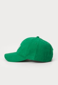 Zöld pamut baseball sapka ívelt karimával, hímezett logóval és állítható hátsó pánttal. A karimán és a koronavégen látható varrás.