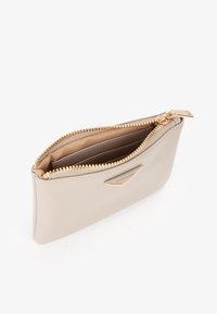 Portafoglio in pelle beige con zip dorata, aperto per mostrare più scomparti per carte all'interno, contrassegnato da una piccola placca metallica dorata "MIRIAD".