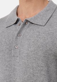 Grijze polo shirt met een textured stof, klassieke kraag, knoopsluiting met drie knopen en een subtiele geborduurde logo op de borst.