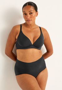 Musta rintaliivi ja korkeavyötäröinen alushoususetti. Täydellinen, joustava kangas, syvä pääntie ja ei näkyviä saumoja saumatonta ilmettä varten.