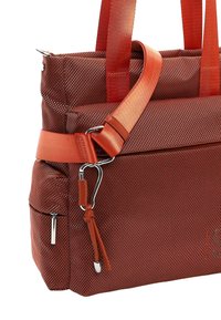 Sarkana teksturēta tote soma ar diviem plecu siksnām, noņemamu pāri ķermenim nēsājamu siksnu un metāla aksesuāriem. Galvenā nodalījuma rāvējslēdzējs.