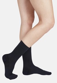 Marineblaue Socken aus geripptem Stoff in mittlerer Wadenlänge mit einem einfarbigen Design und einer glatten, weichen Textur.