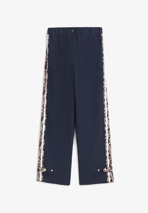 Pantalon bleu marine texturé avec des bandes latérales marron à motifs. Il présente une taille élastique et des liens aux poignets avec des accents métalliques.