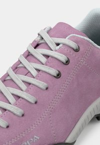 Sapatilhas em camurça rosa claro, com atacadores cinzentos, ilhós cinzentos e uma sola de borracha texturizada. Apresenta costura em contraste e um interior acolchoado.
