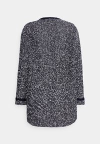 Granatowo-biały długorękawowy top w cętki z okrągłym dekoltem i kontrastującą czarną lamówką przy mankietach. Miękka, teksturowana tkanina o luźnym kroju.