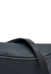 Zwarte leren handtas met een gestructureerde afwerking, voorzien van een ritsluiting en een enkele strap. Eenvoudig, rechthoekig ontwerp met een subtiele glans.