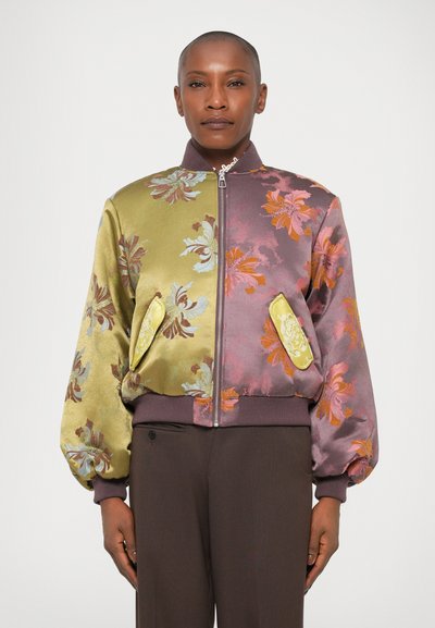 Blumige Bomberjacke mit seidiger Textur, einer Mischung aus grünen und lila Farbtönen, gerippten Bündchen und zwei dekorativen Seitentaschen.