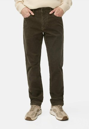 Dark green corduroy pants with a straight fit, featuring front pockets, a button closure, and a soft texture. Paired with light sneakers.
