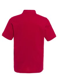 Polo rouge en coton, avec un col, des manches courtes et une coupe régulière avec des fentes sur les côtés pour plus de liberté de mouvement.