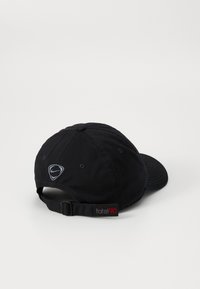 Sort baseballcap lavet af stof med en buet skygge, har et sølvfarvet Nike-logo på fronten og et rødt 'total90'-mærke på bagsiden.