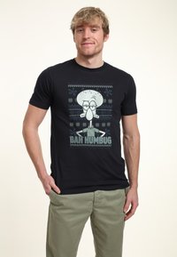 �Černé bavlněné tričko s grafikou kreslené postavičky "Squidward" a textem "BAH HUMBUG" ve světle modré barvě.
