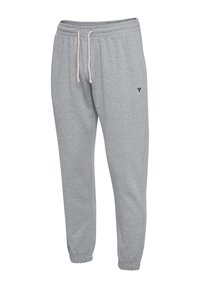 Graue Sweatpants aus weichem Material, mit einem elastischen Bund mit Kordelzug, enganliegenden Bündchen und einem kleinen schwarzen Logo auf dem Oberschenkel.