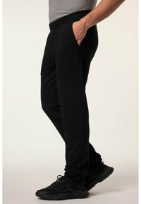 Czarne spodnie dresowe z elastycznym pasem, z bocznymi kieszeniami i zwężanym krojem nogawek, wykonane z miękkiej, lekkiej tkaniny.