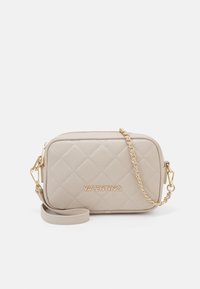 Beige quilted leather crossbody bag with gold hardware. Features a chain strap and embossed logo on the front. Rectangular shape.