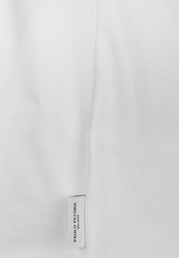 Tessuto di cotone bianco con una superficie liscia, con un'etichetta che riporta "Paolo Pecora Milano" nell'angolo in basso a destra.