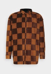 Chemise à carreaux marron et orange en matière polaire douce, avec un col, une fermeture à boutons sur le devant et des manches longues.