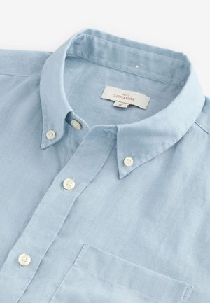 Lichtblauw linnen overhemd met knopen, klassieke kraag, witte knopen en een borstzak. Label met "NEXT SIGNATURE M."