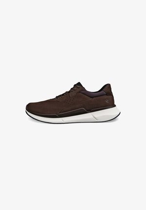 Brązowe zamszowe sneakersy z białą i czarną podeszwą, teksturowanymi akcentami oraz perforowanymi detalami w górnej części, które zapewniają oddychalność.