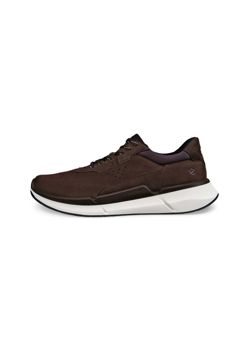Braune Wildleder-Sneaker mit einer weiß-schwarzen Sohle, strukturierten Akzenten und perforierten Details im Obermaterial für Atmungsaktivität.